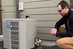 photograph of technician using a smart diagnostic device at a house